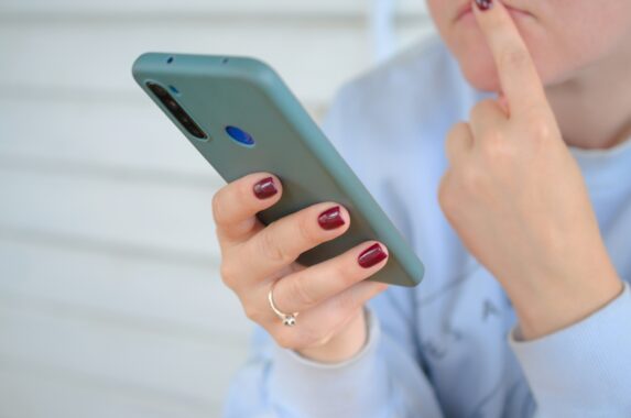 スマホを持ちながら見ている女性