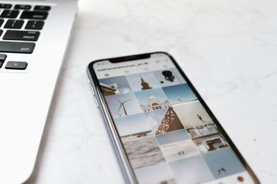机の上にインスタが開かれているスマホが置かれている